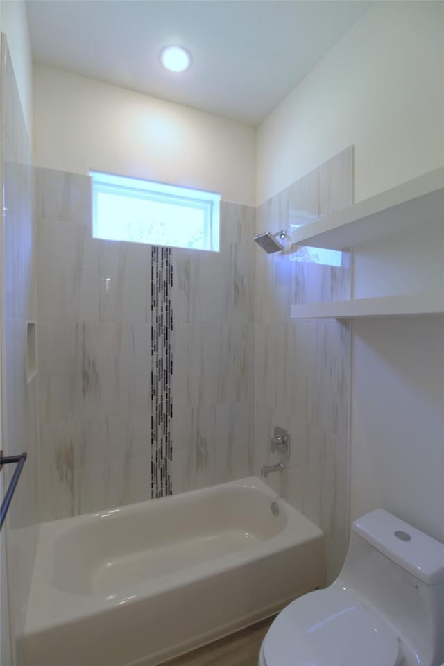 bathroom featuring toilet, tiled shower / bath combo, and wood-type flooring