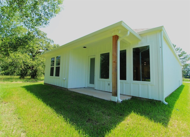 back of property featuring a patio area and a yard