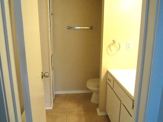 bathroom featuring toilet, tile patterned flooring, and vanity