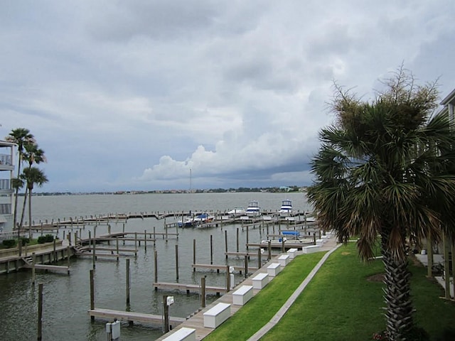 view of dock with a water view and a lawn