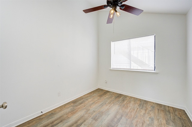 empty room featuring vaulted ceiling, ceiling fan, and hardwood / wood-style floors