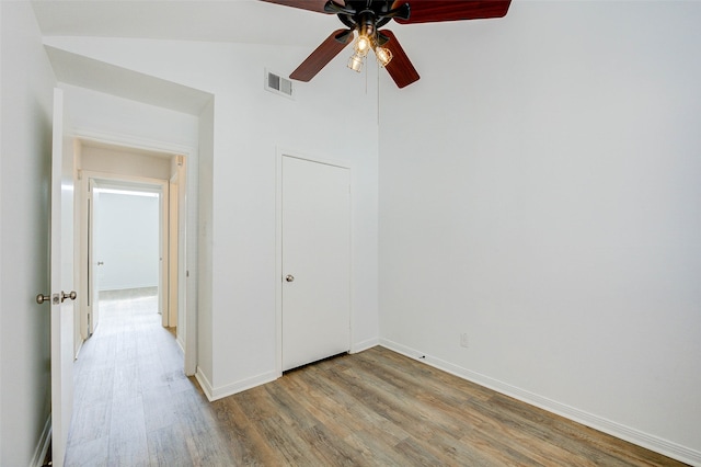 unfurnished bedroom with ceiling fan, hardwood / wood-style flooring, and lofted ceiling