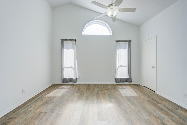 spare room with hardwood / wood-style flooring, high vaulted ceiling, and ceiling fan