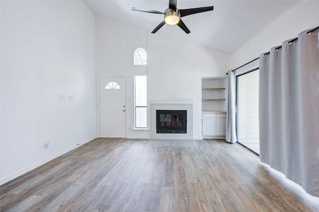 unfurnished living room with ceiling fan, hardwood / wood-style flooring, and high vaulted ceiling