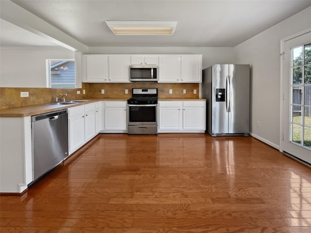 kitchen with backsplash, stainless steel appliances, dark hardwood / wood-style floors, and a healthy amount of sunlight