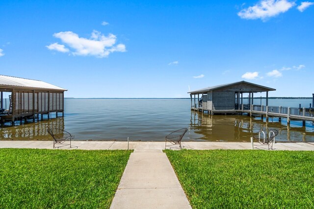 dock area with a lawn and a water view