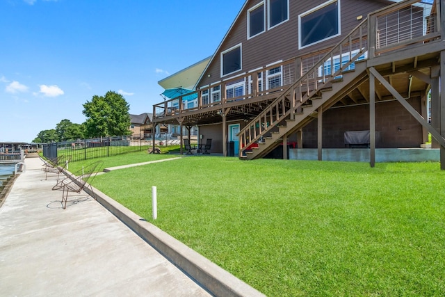 back of property featuring a wooden deck and a yard