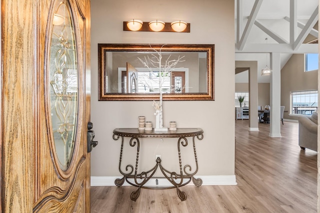 corridor featuring hardwood / wood-style floors and vaulted ceiling