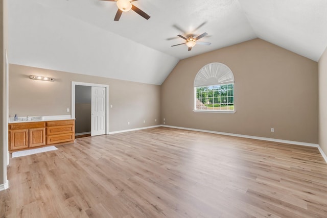 unfurnished living room featuring sink, vaulted ceiling, light hardwood / wood-style floors, and ceiling fan