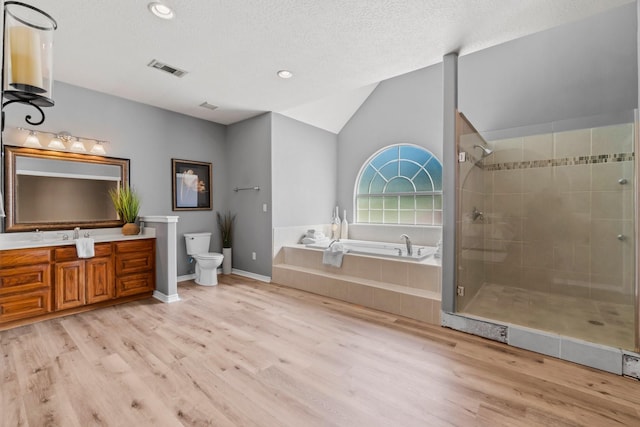 full bathroom with toilet, vaulted ceiling, vanity, independent shower and bath, and hardwood / wood-style flooring