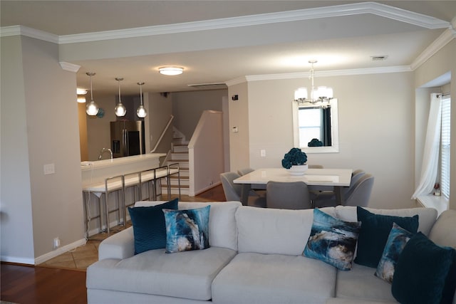 living room featuring light wood-type flooring, an inviting chandelier, a wealth of natural light, and ornamental molding