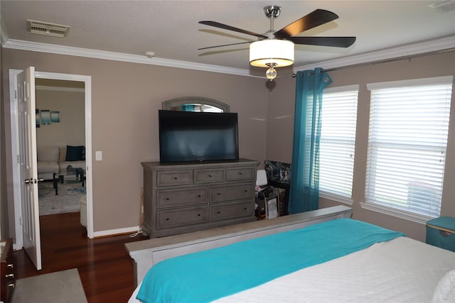 bedroom with dark hardwood / wood-style flooring, ceiling fan, and crown molding