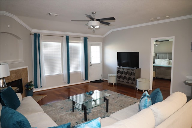 living room featuring dark hardwood / wood-style flooring, lofted ceiling, crown molding, and a tiled fireplace