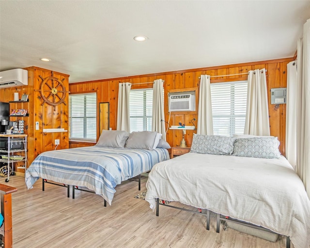 bedroom featuring light wood finished floors, a wall unit AC, a wall mounted air conditioner, and wooden walls