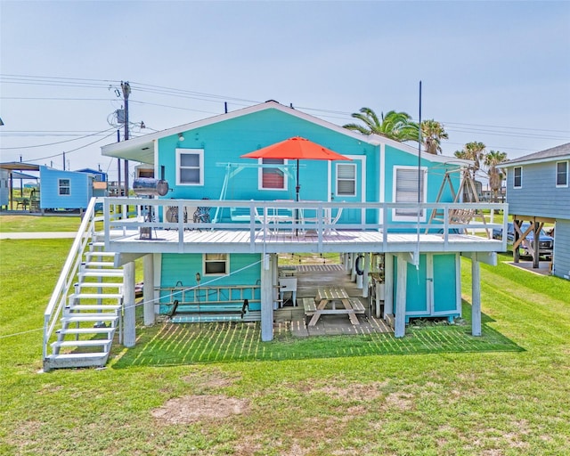 back of property with stairway, a deck, and a yard