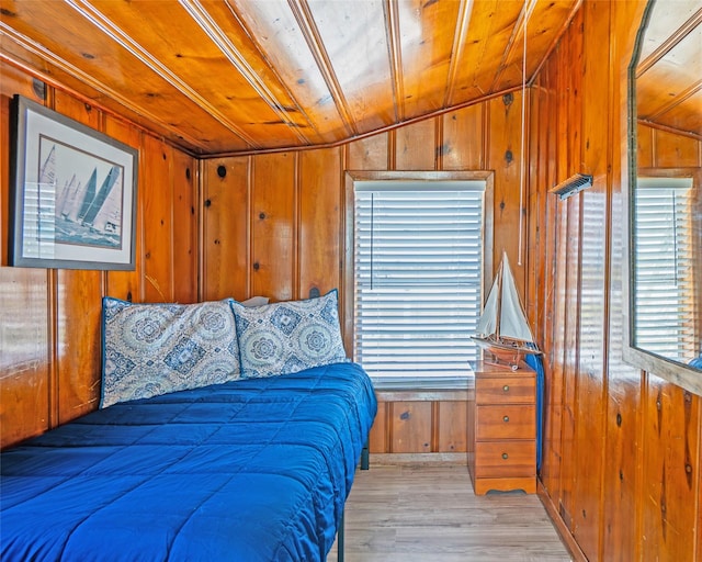 bedroom featuring light wood-style floors, wood ceiling, wooden walls, and vaulted ceiling