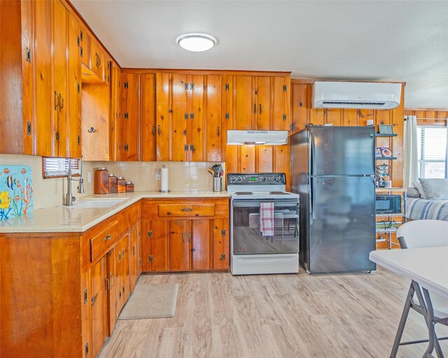 1214 County Road 201, Sargent, TX 77414 - kitchen featuring freestanding refrigerator, white range with electric cooktop, under cabinet range hood, a wall mounted AC, and light countertops