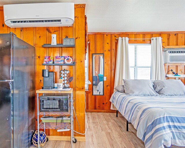 1214 County Road 201, Sargent, TX 77414 - bedroom with freestanding refrigerator, a wall mounted air conditioner, wood finished floors, a wall unit AC, and wooden walls