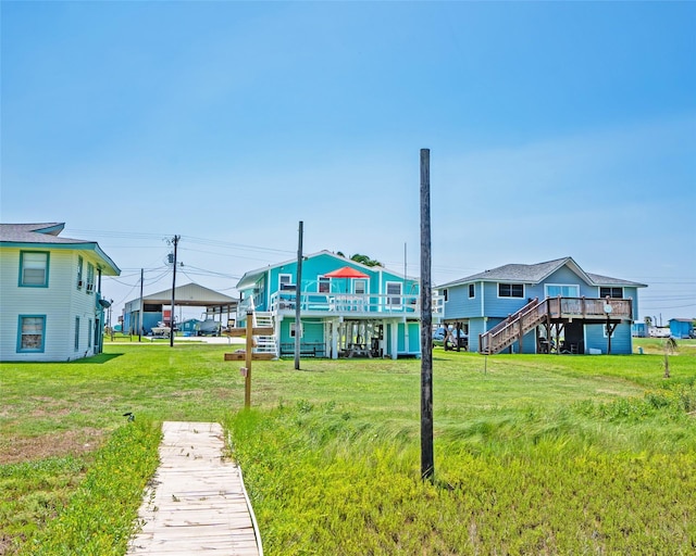 rear view of house featuring a deck, a yard, and stairway