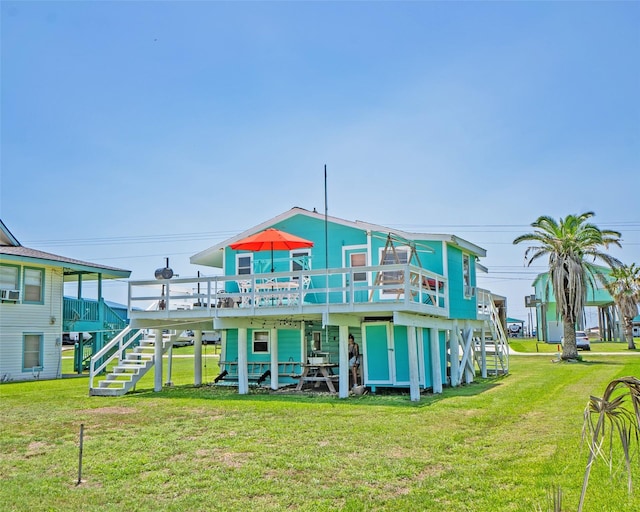 back of property featuring stairs, a deck, and a lawn