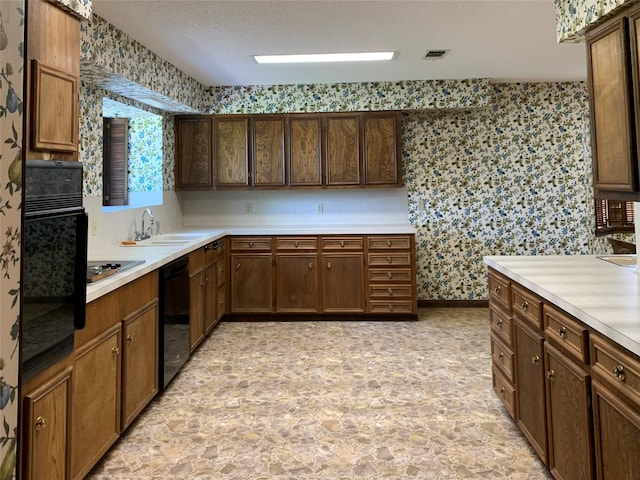 kitchen featuring black appliances, sink, and a textured ceiling