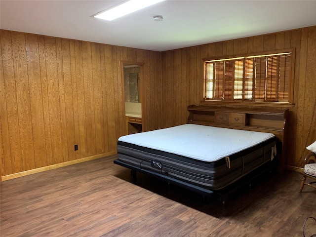 bedroom with wooden walls and hardwood / wood-style floors