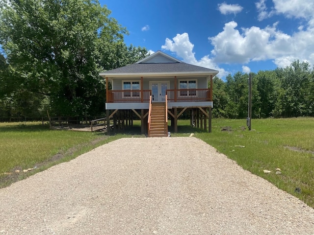 view of front of home with covered porch and a front lawn