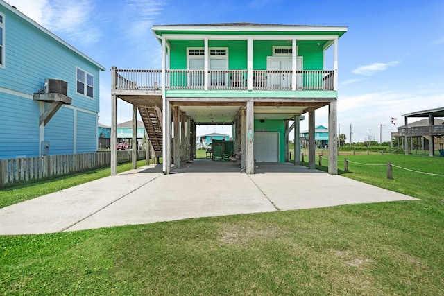 back of property with a porch, a garage, a lawn, and a carport