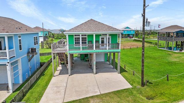 back of property featuring a garage, a yard, a porch, and a carport