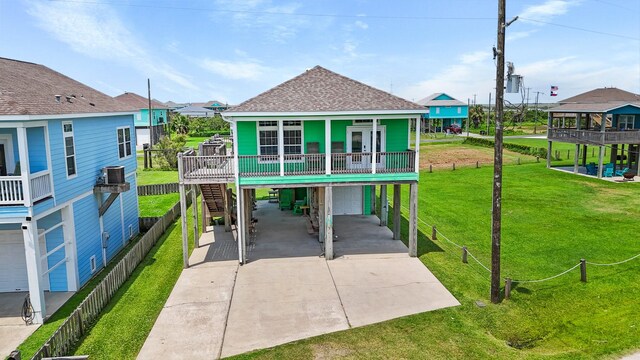 view of front of home with a garage, central AC, a front lawn, and a porch