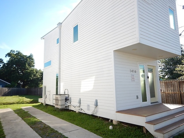 view of property exterior featuring a wooden deck and a yard