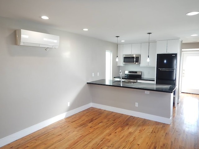 kitchen featuring pendant lighting, white cabinetry, kitchen peninsula, and appliances with stainless steel finishes