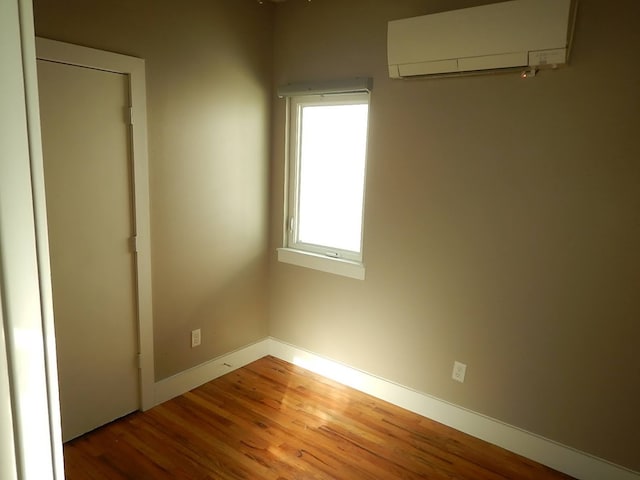 spare room with light hardwood / wood-style floors and a wall mounted AC