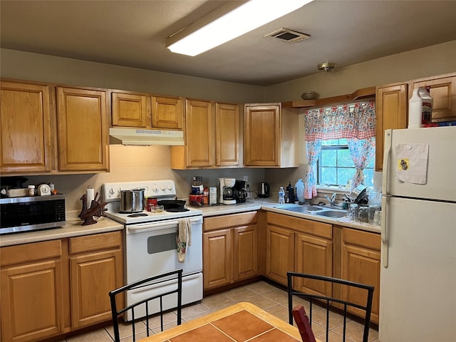 kitchen with white appliances, sink, and light tile patterned floors