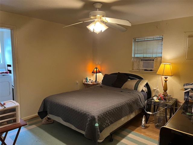 bedroom featuring washer / clothes dryer, ceiling fan, cooling unit, and wood-type flooring