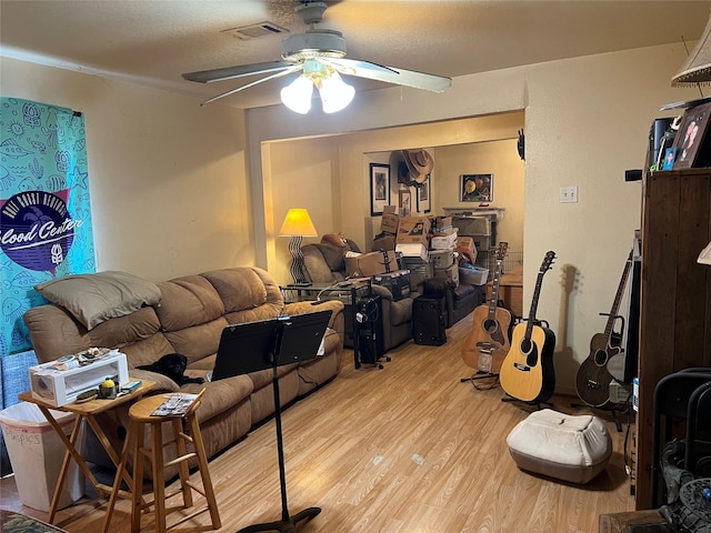 living room featuring a textured ceiling, light hardwood / wood-style flooring, and ceiling fan