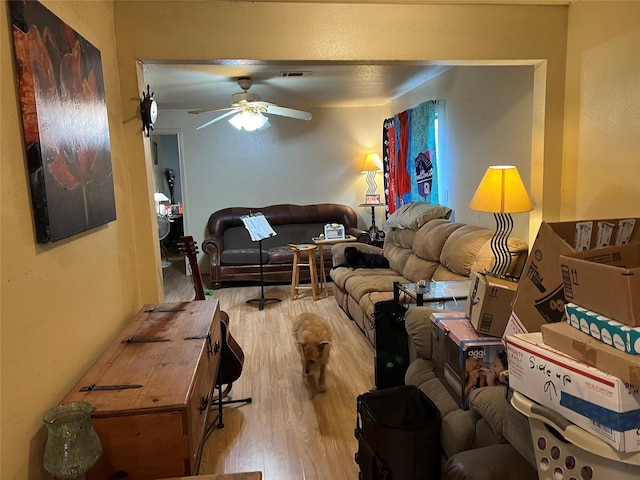 living room featuring light hardwood / wood-style flooring and ceiling fan