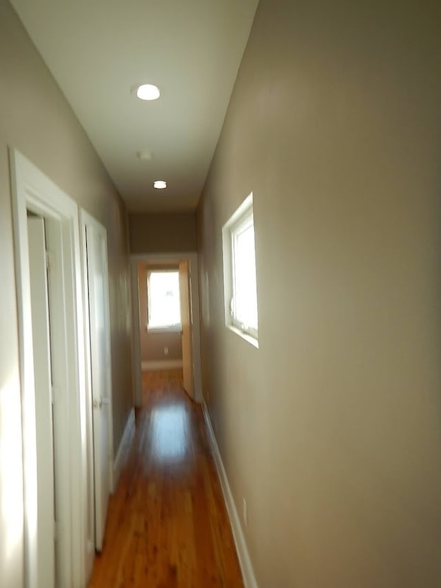 hallway with hardwood / wood-style flooring