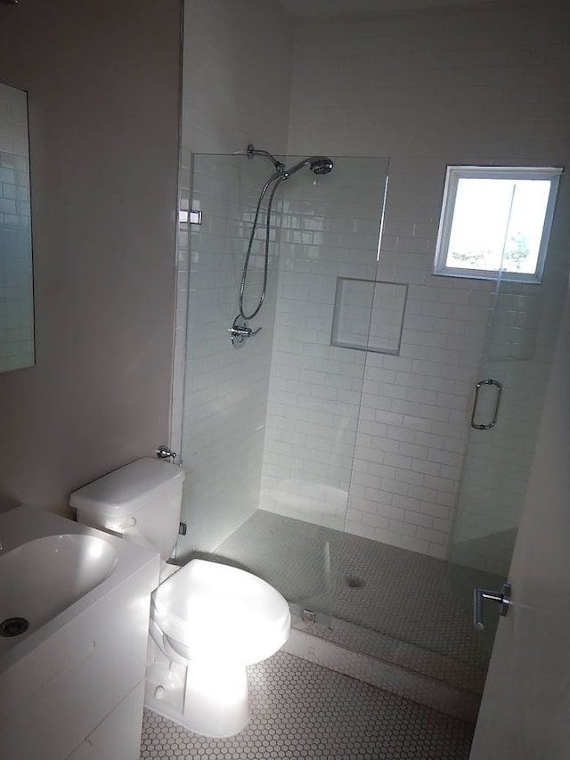 bathroom with tile floors, walk in shower, and toilet