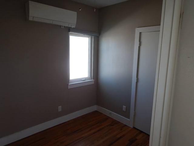 empty room featuring wood-type flooring and an AC wall unit