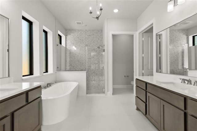 full bathroom featuring plenty of natural light, vanity, a chandelier, and shower with separate bathtub