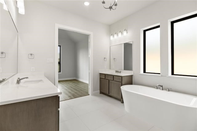 bathroom featuring vanity, a tub to relax in, tile patterned floors, and a notable chandelier