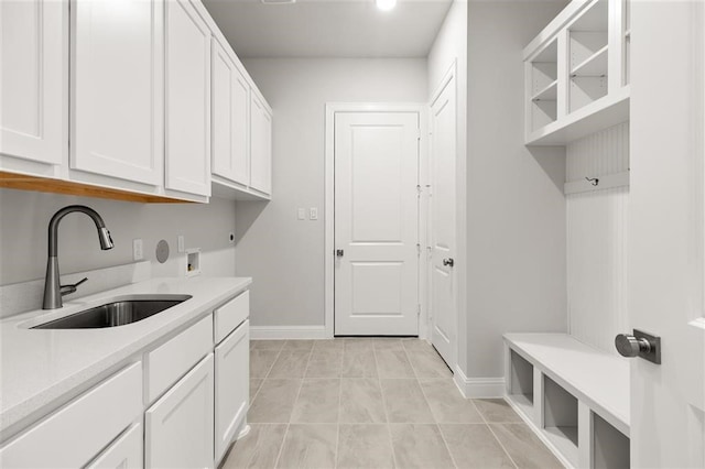 laundry area with cabinets, washer hookup, hookup for an electric dryer, sink, and light tile patterned floors