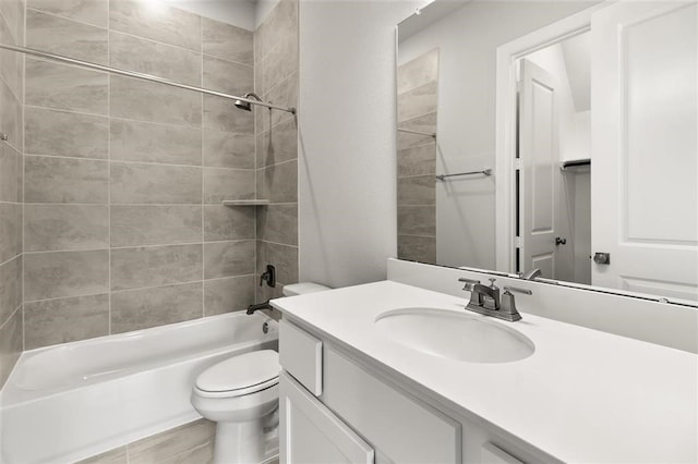 full bathroom featuring vanity, tiled shower / bath combo, and toilet