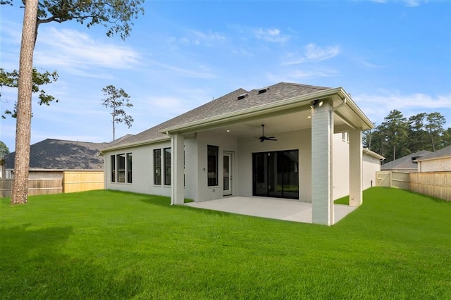 rear view of property with a lawn, a patio area, and ceiling fan