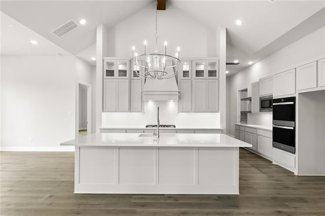 kitchen featuring white cabinetry and an island with sink