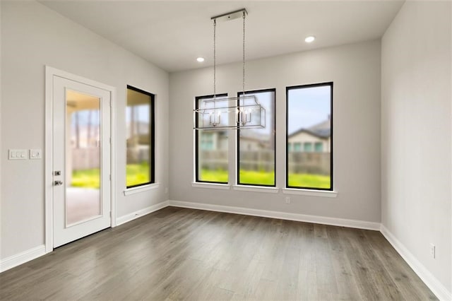 empty room featuring hardwood / wood-style floors and a chandelier