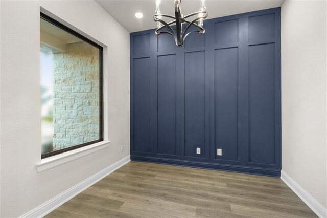 spare room with a chandelier and hardwood / wood-style floors