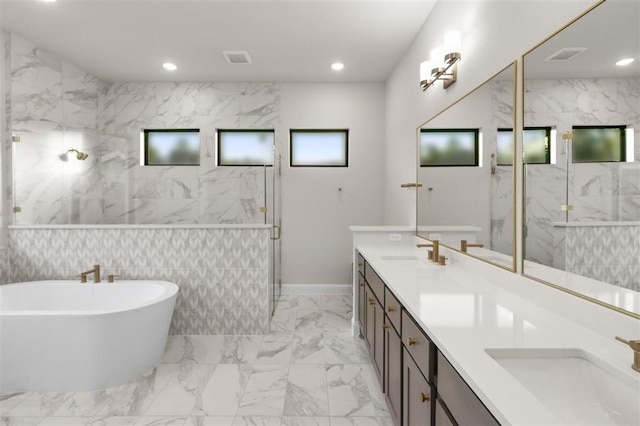 bathroom with separate shower and tub, vanity, and tile walls