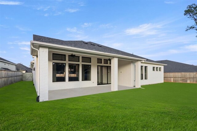 back of property featuring ceiling fan and a lawn